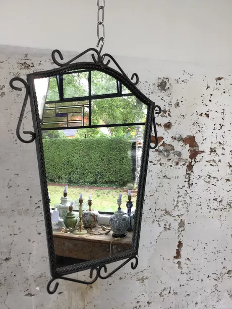 Wandspiegel mid-century met smeedijzeren ornamentering, gekartelde rand. Hardboard rugplaat. Weegt ruim 3 kg. Glas heeft slechts enkele zeer lichte slijtageplekjes.
