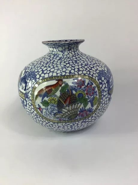 Engelse Vaas Drie Taferelen Gesigneerd Adams Late 18de eeuw Deze opmerkelijk Engelse vaas toont aan drie motieven: een Chinese vogel op een mand met bloemen en vruchten, een ontmoeting met een jonge Confusius en een ontmoeting met een oudere Confusius. Bijzonder aan dit motief is het perspectief van de mand. Deze vaas en het deksel zijn puntgaaf en onbeschadigd. De vaas aan de onderzijde gesigneerd: ReNo 623294 Adams 5625.