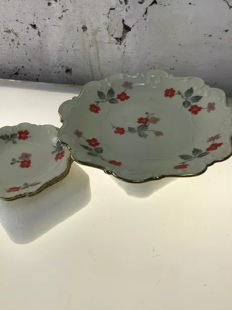 Vijf kleine schaaltjes en 1 klein bord met hetzelfde decoratief motief van een rode bloem met grijs blad. Gemaakt tussen 1913 en 1954.