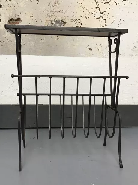 Dit Mid century tijdschriftenrek heeft een smeedijzeren bovenframe waarin drie geëmailleerde tegels liggen van helder chilirood en smaragdgroen keramiek. Op de vier poten zitten zwarte rubberen beschermdoppen. Het geheel is puntgaaf en onbeschadigd. Geen restoratieplekken zichtbaar.