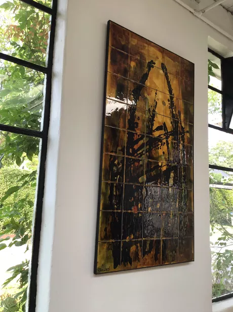 Dit Belarti-paneel bestrijkt vijfenveertig met de hand beschilderde keramische tegels die samen een krachtige abstractie tonen, ingelegd in een zwart frame. De stijl sluit aan bij de mid-century modern esthetiek en is verwant aan de West-Europese traditie van naoorlogse designkeramiek. Dit kunstwerk weegt meer dan 20 kg en is geschikt als wanddecoratie.