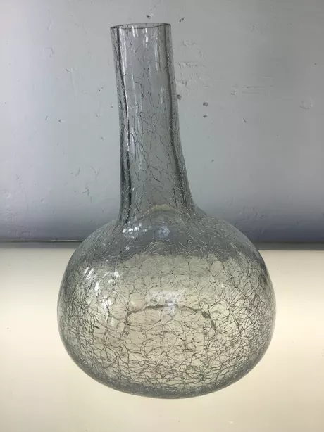 Deze vaas is handgemaakt van glas en heeft een uniek craquelé-effect aan de zijkant en onderkant.