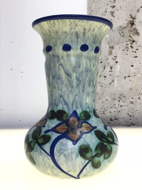 Deze zeldzame vaas werd gemaakt in Zweden in de jaren '50. Donkerblauwe pasteuze rand. Handgeschilderd voorzien van bloem- en bladmotief op een lichtblauwe achtergrond. "UE" gesigneerd aan de onderzijde. Deze vaas is onbeschadigd en puntgaaf.